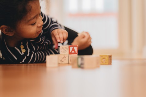 Young student with letter blocks. 