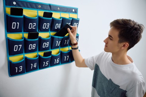 High school student leaving his smart phone in cell phone organizer