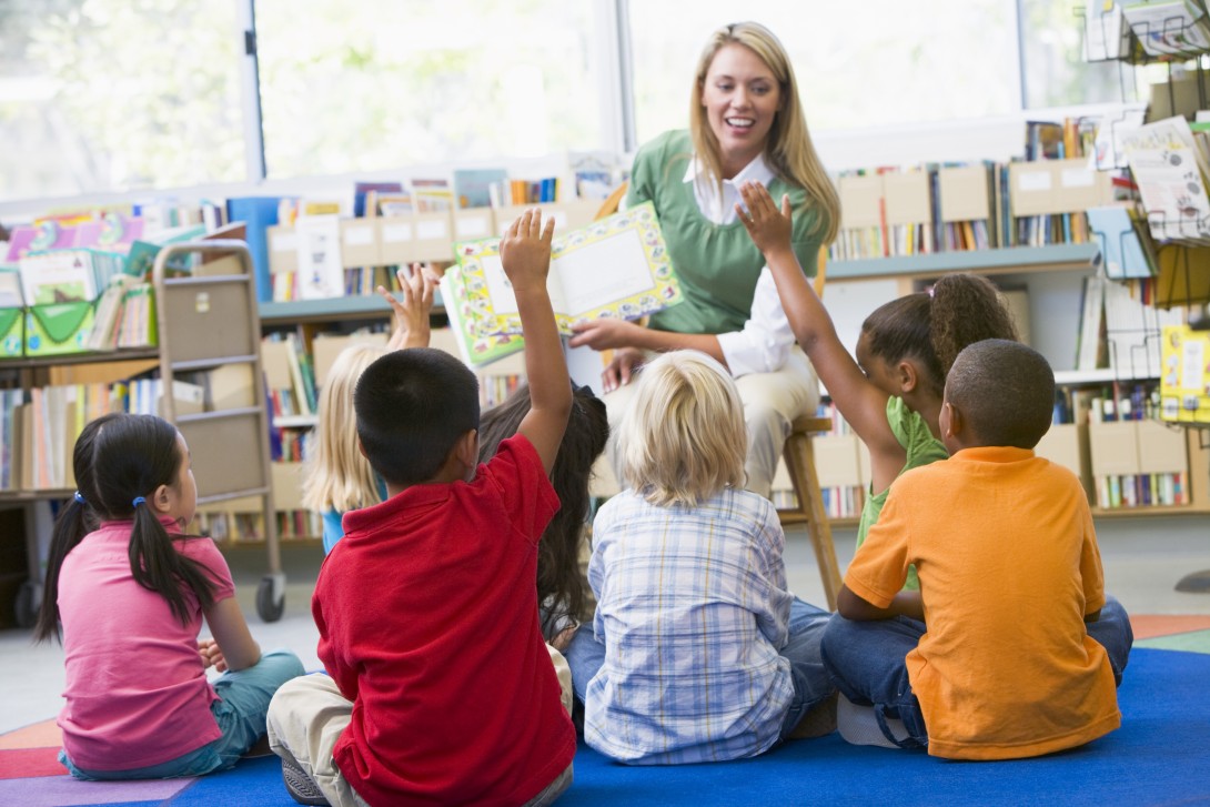 A teacher reading aloud to a group of students.